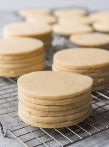 stacks of unfrosted sugar cookies on a wire cooling rack