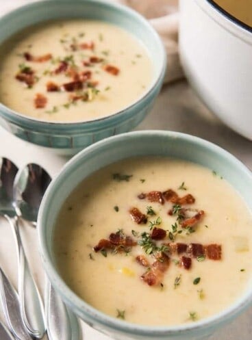 irish leek soup in two bowls garnished with bacon