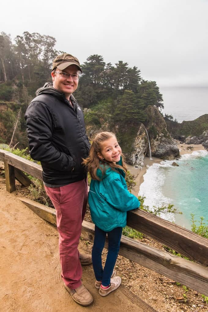 An image of a father and daughter at McWay Falls in Big Sur, California.