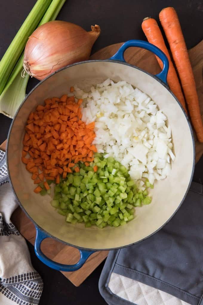 An image of chopped carrots, celery and onion in a dutch oven to make an Italian soffritto or battuto.
