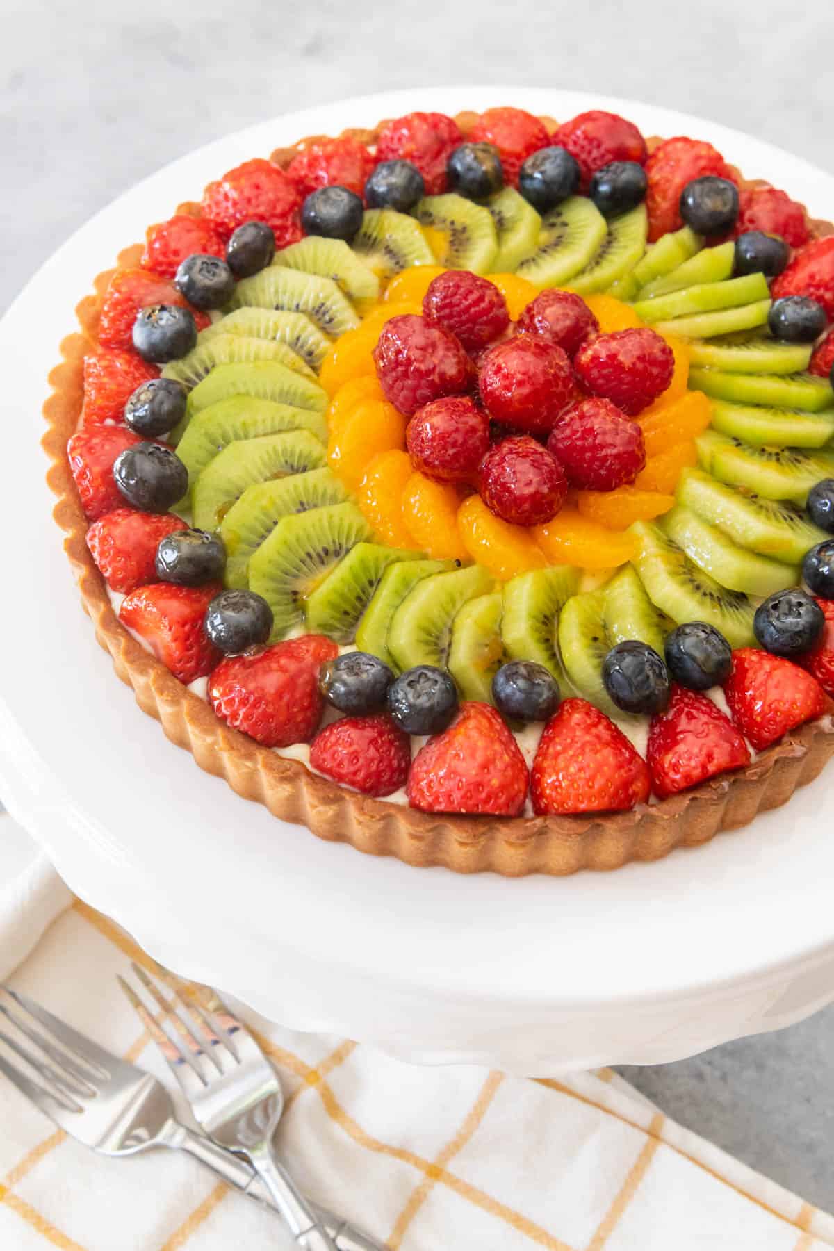 An image of a tart made with mixed fruit in concentric circles, made with a French fruit tart recipe.