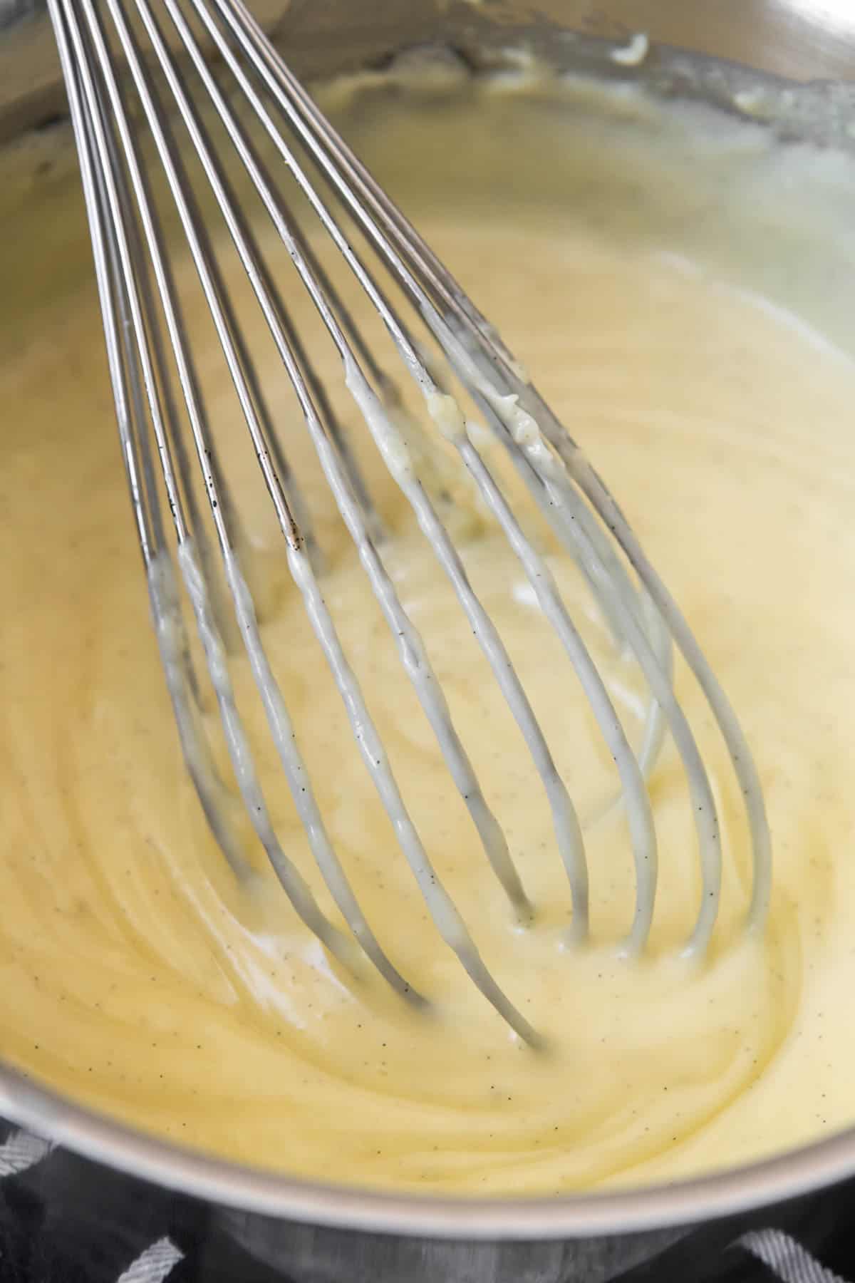 Pastry cream is whisked and cooked on the stove just until thickened.