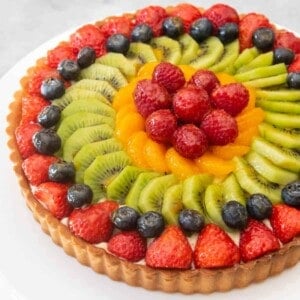 A French fruit tart with strawberries, raspberries, blueberries, kiwis, and mandarin oranges.