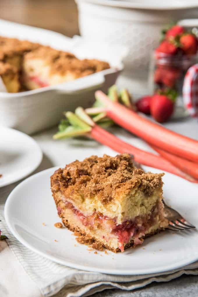 a slice of rhubarb coffee cake on a white plate with a fork