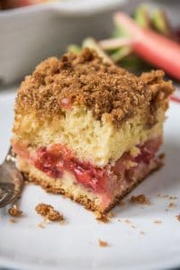 An image of a slice of cinnamon crumb coffee cake with a thick layer of strawberry rhubarb filling in the middle.