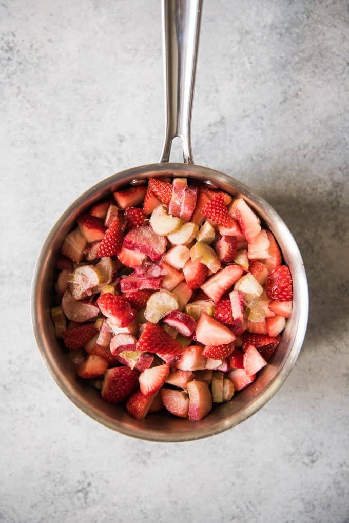 An image of a saucepan with chopped rhubarb and strawberries to make a strawberry rhubarb jam for coffee cake.