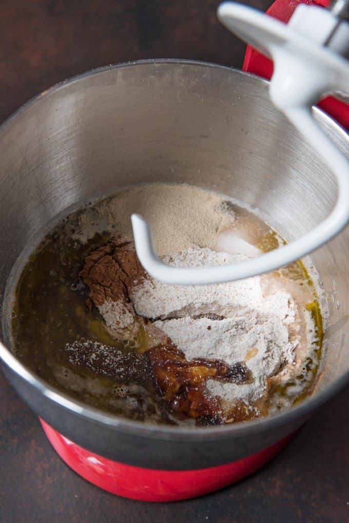 Mixing ingredients together for sweet molasses brown bread in a stand mixer fitted with a dough hook attachment.