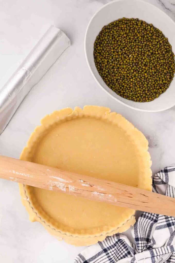 Pressing a pastry crust into a tart pan.