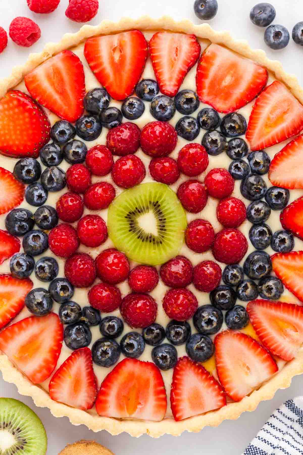 An image of a tart made with mixed fruit in concentric circles, made with a French fruit tart recipe.