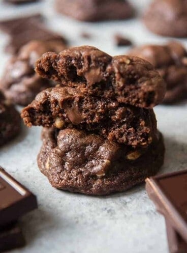 stack of chocolate brownie cookies with top cookie broken in half to show inside