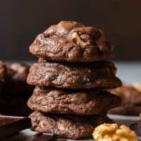 chocolate cookies next to chocolate and a walnut
