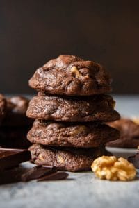 chocolate cookies next to chocolate and a walnut