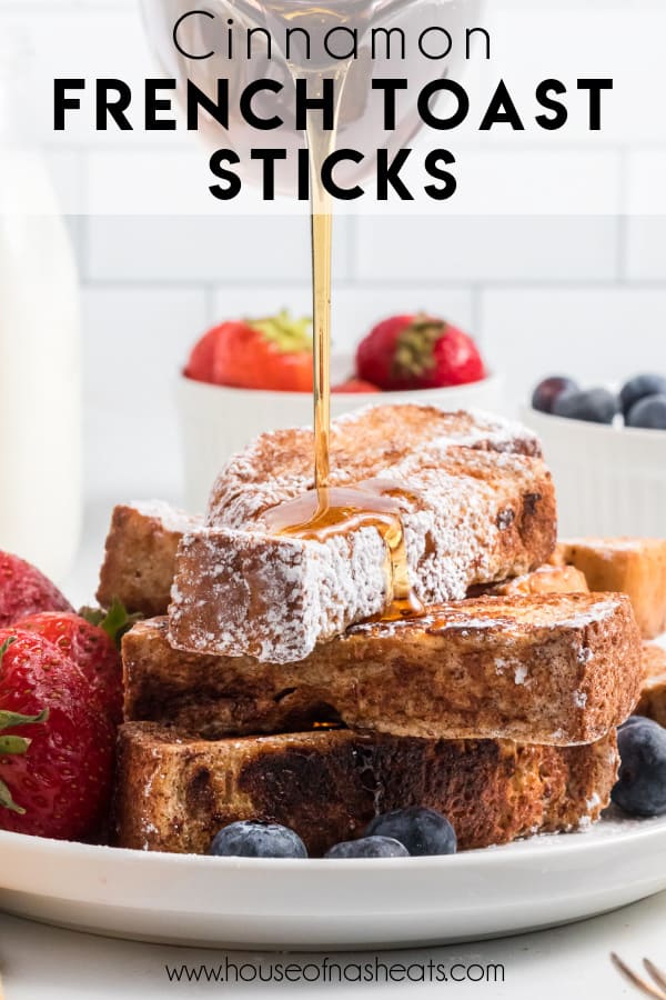 A stack of French toast sticks with maple syrup being drizzled on top.