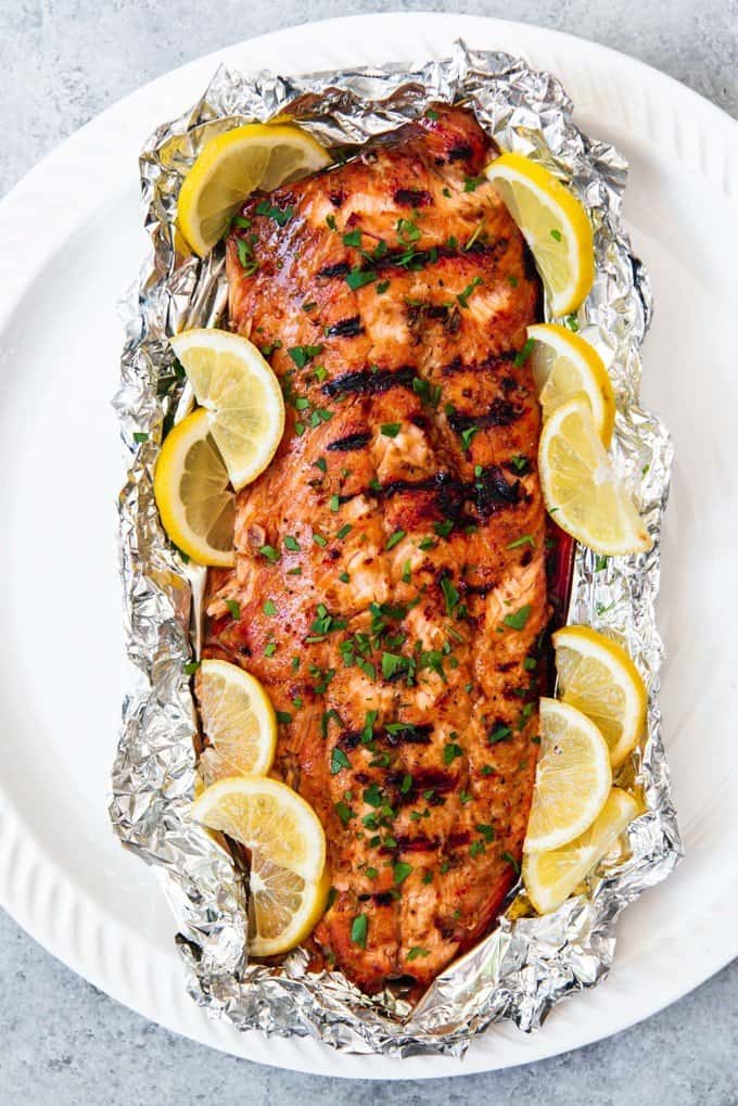 An image of a large piece of salmon grilled in foil on the grill.