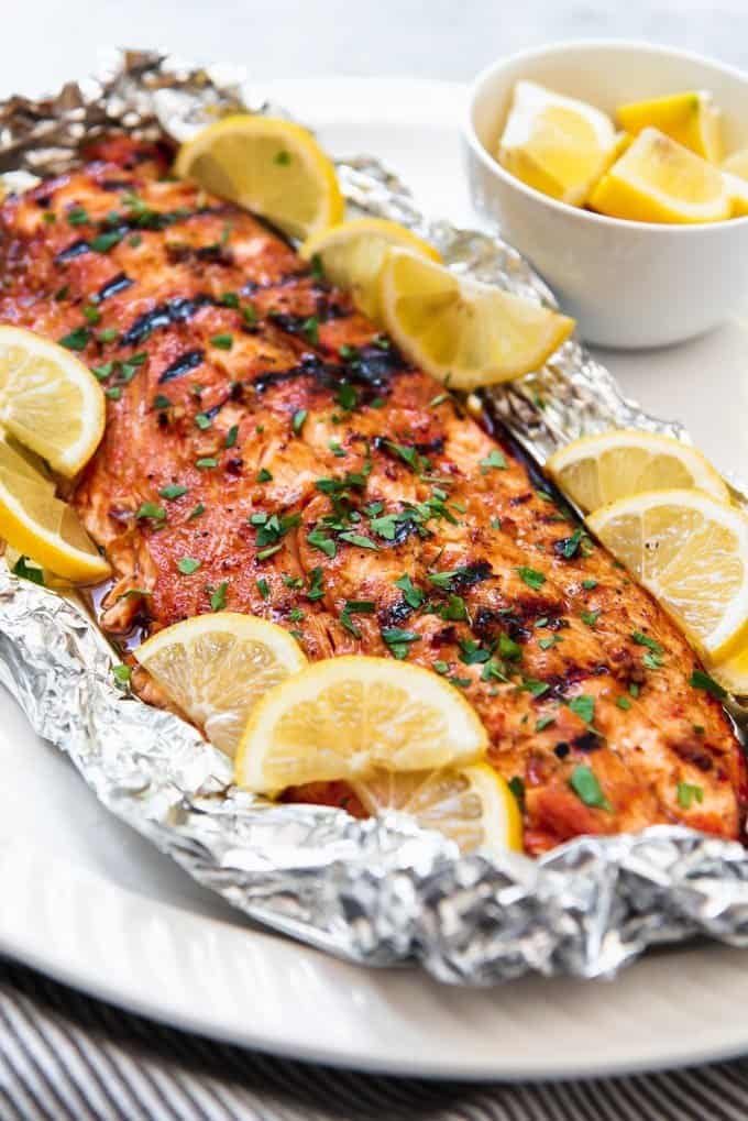 An image of grilled salmon made with a garlic soy brown sugar marinade, then wrapped in foil to go on the grill.
