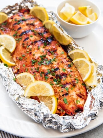 a grilled salmon in a foil packet with lemon wedges