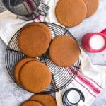 Joe Froggers Cookies scattered around a wire rack with measuring cups and tools to the side