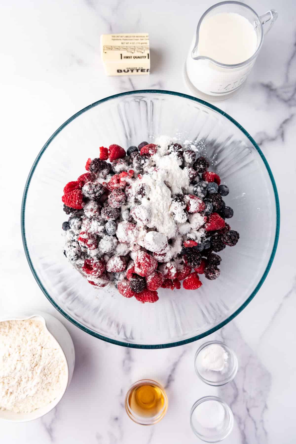 Combining berries with flour and sugar in a bowl.