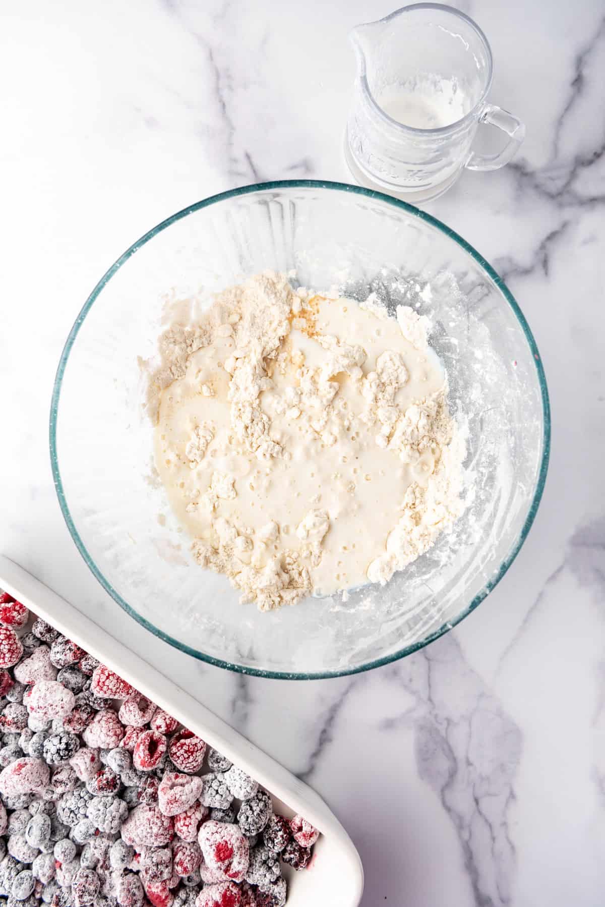 Adding wet ingredients to dry ingredients to make cobbler topping.