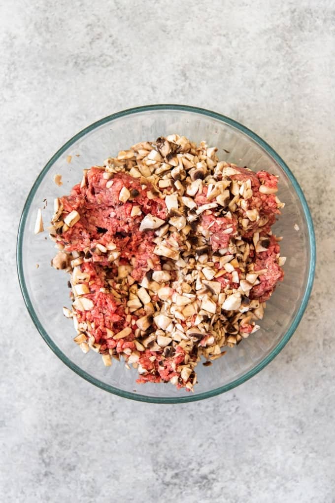 An image of a bowl of lean ground beef and chopped mushrooms being blended together.