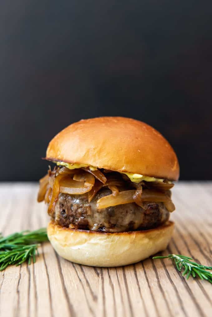a deliciously golden colored mushroom swiss burger with carmelized onions
