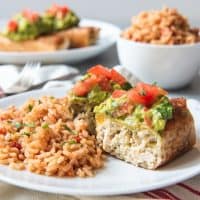 An image of a chicken chimichanga sliced open and served with Spanish rice.