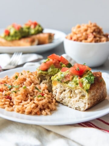 An image of a chicken chimichanga sliced open and served with Spanish rice.