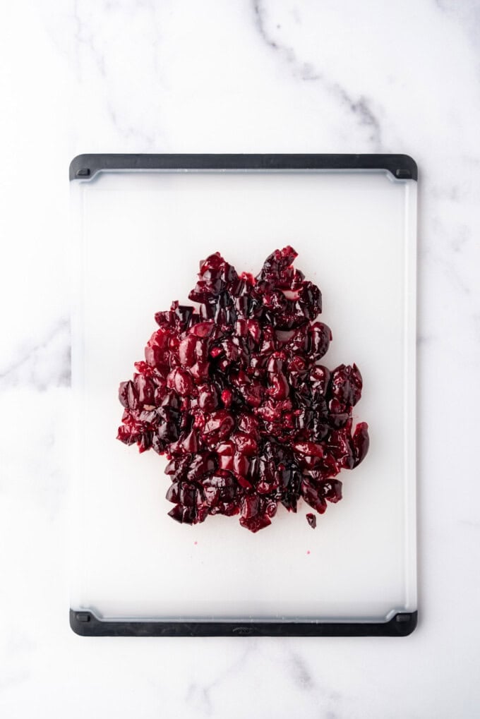 Chopped cherries on a cutting board.