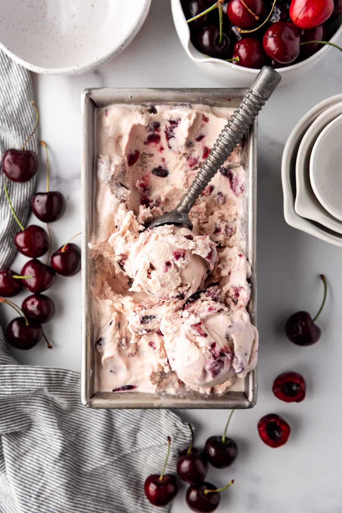 An overhead image of a batch if black cherry ice cream with a scoop.