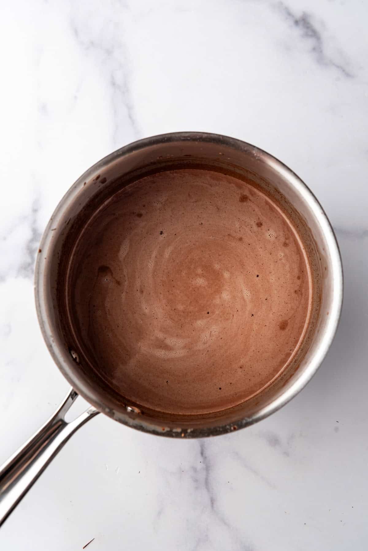 Warm chocolate ice cream base in a saucepan.