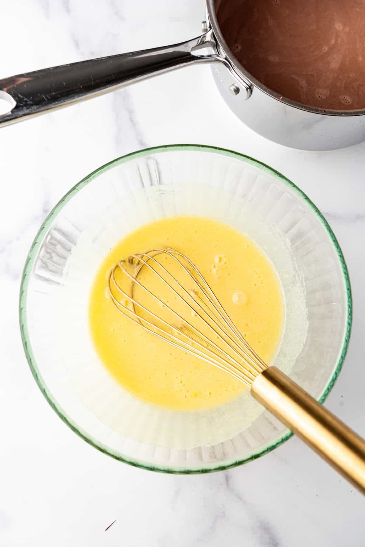 Whisked sugar and egg yolks in a large bowl.