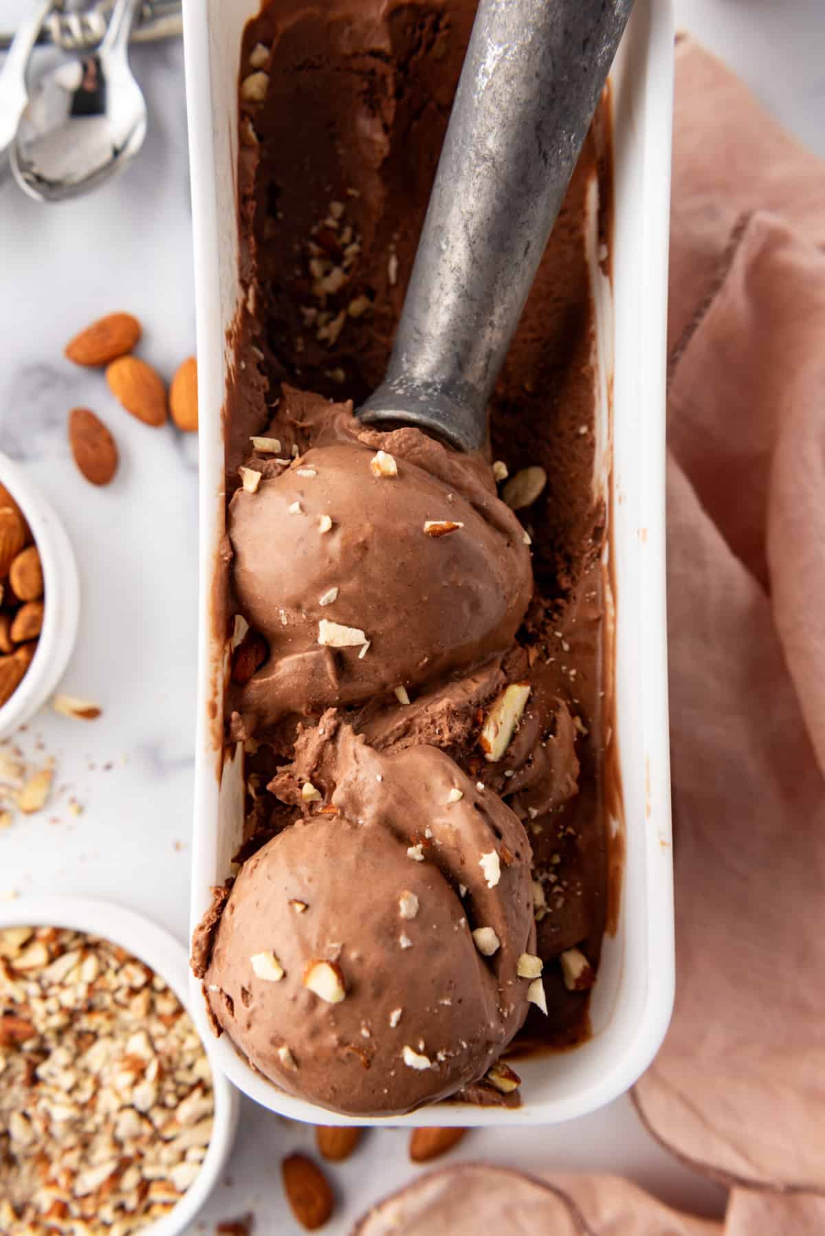 A close up image of scoops of rich burnt almond fudge chocolate ice cream.