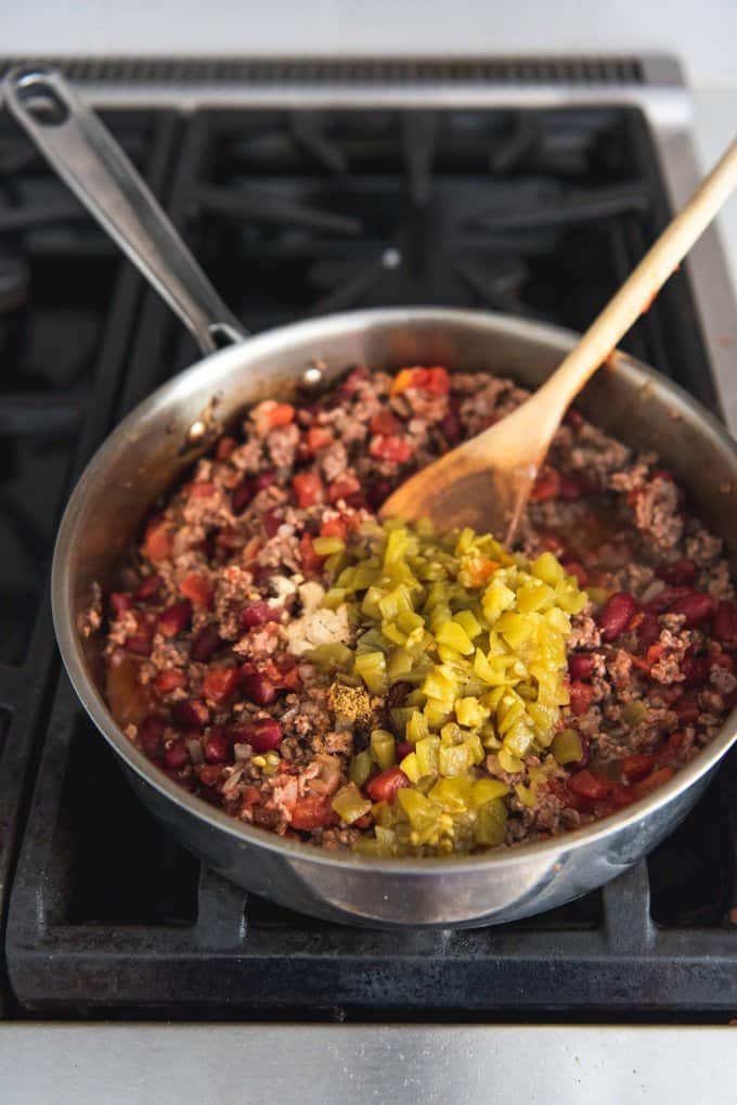 An image of a pan with browned ground beef, kidney beans, green chilies and spices for making taco meat for Navajo tacos.