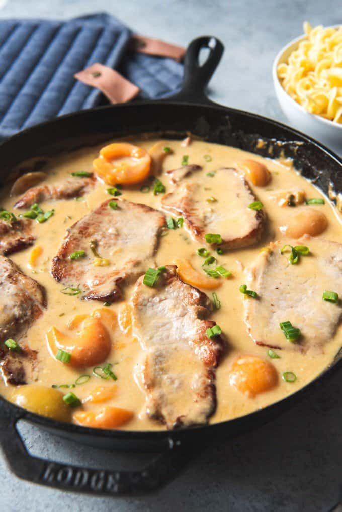 a Lodge cast iron skillet full of creamy apricot porkchops
