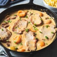 a Lodge cast iron skillet full of creamy apricot porkchops