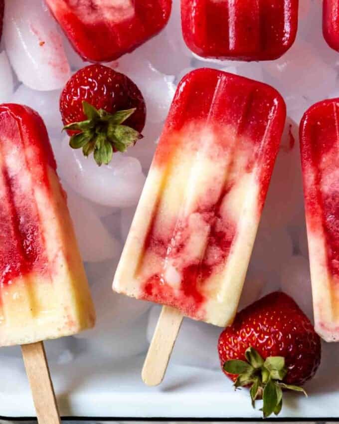 An image of swirled strawberry pineapple popsicles with a hint of coconut.