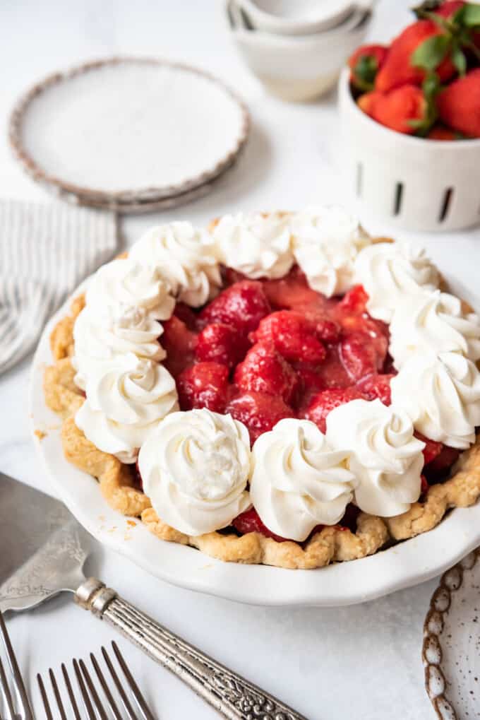 A fresh strawberry pie with whipped cream.