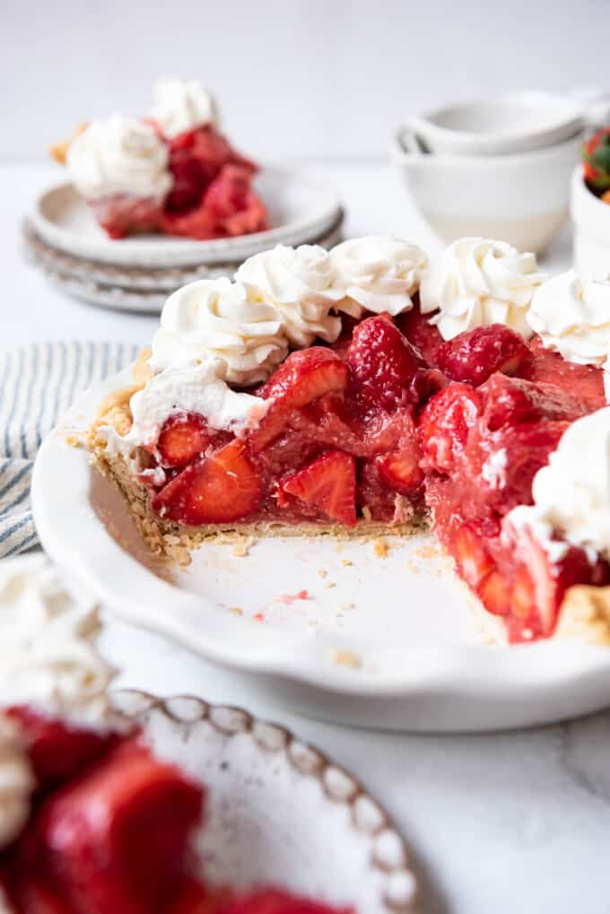 A homemade strawberry pie with some slices removed showing the strawberry glaze filling made with fresh strawberries and no jell-o.