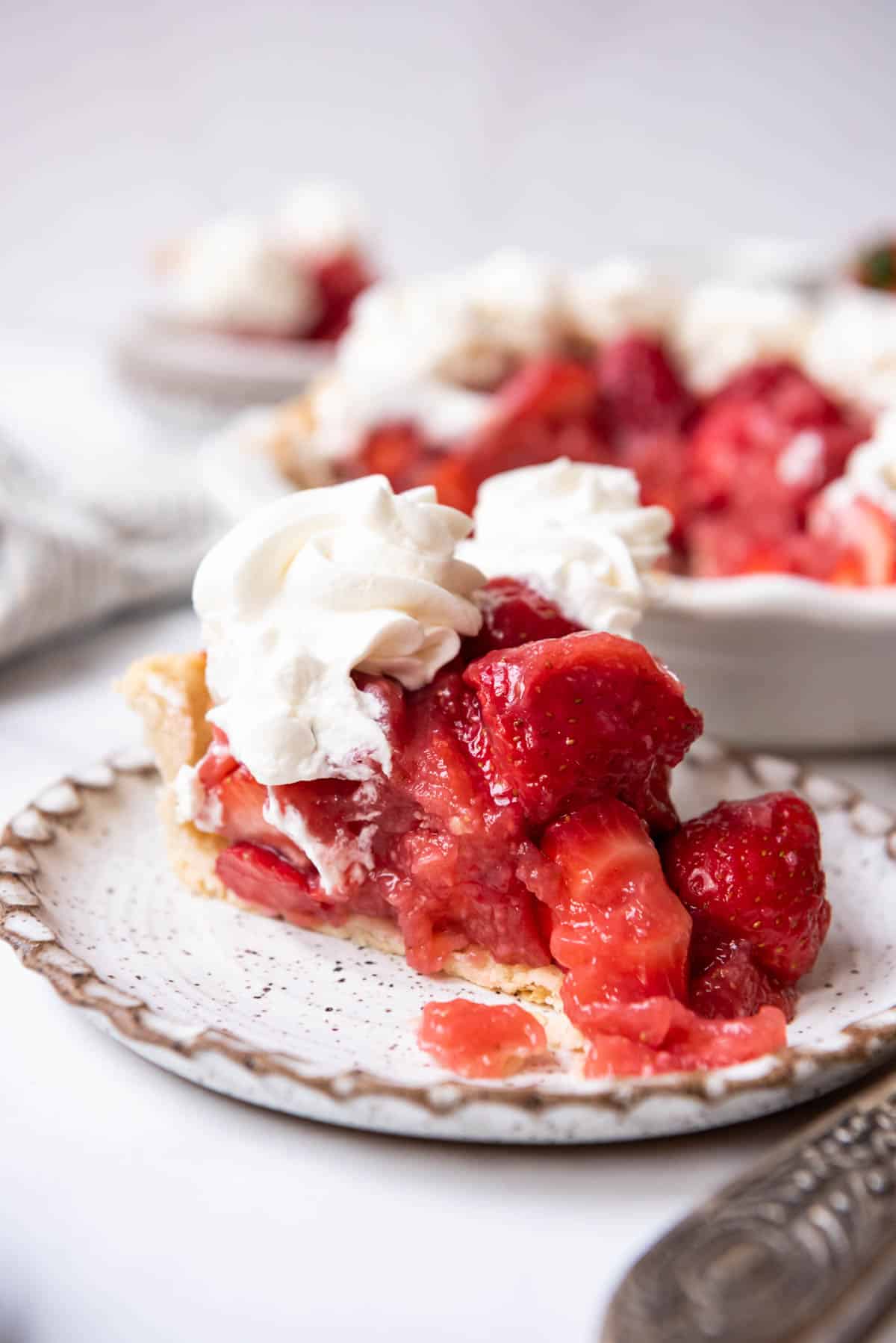 A slice of fresh strawberry pie made without jello on a plate.