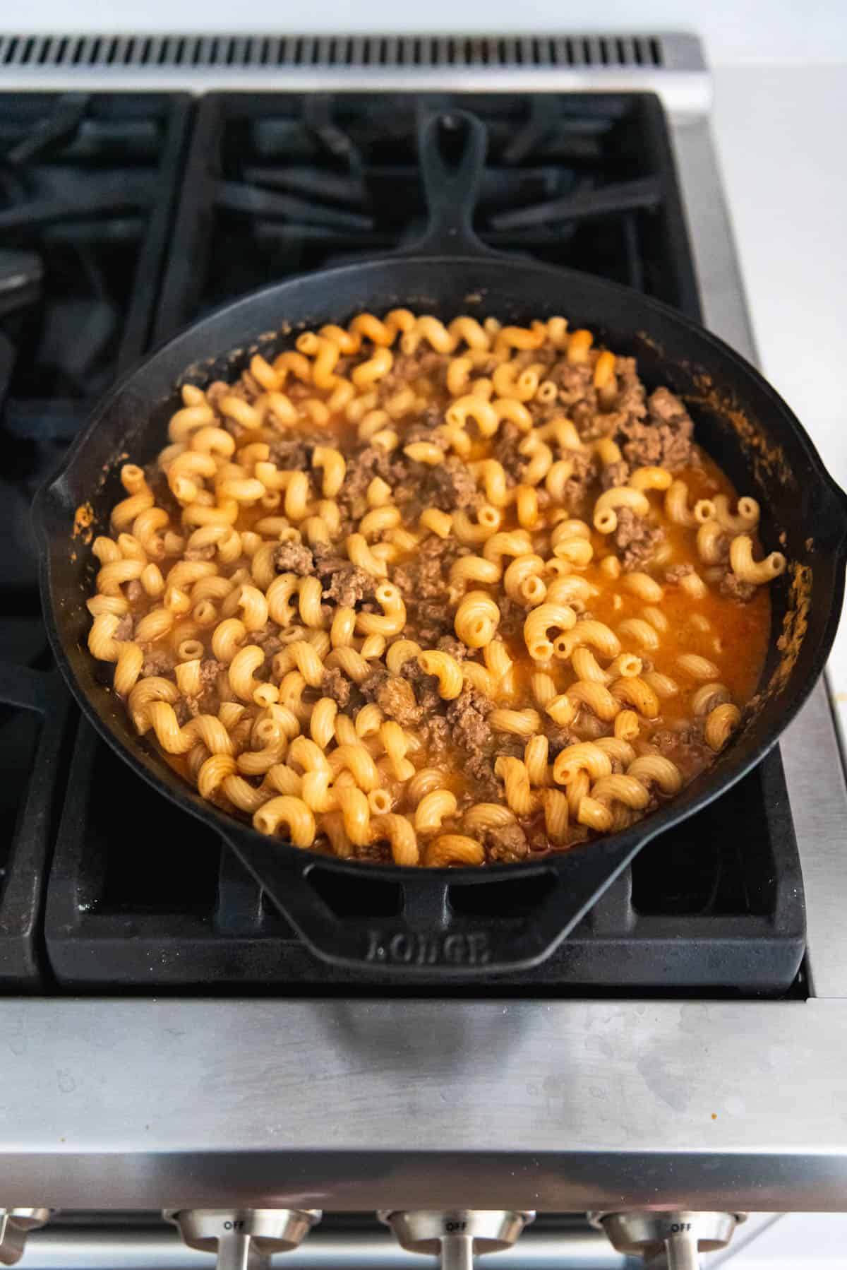 An image showing how to make one pot homemade hamburger helper on the stovetop.