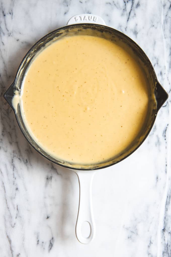An image of a skillet of homemade mustard cheese sauce for dipping soft pretzels in.
