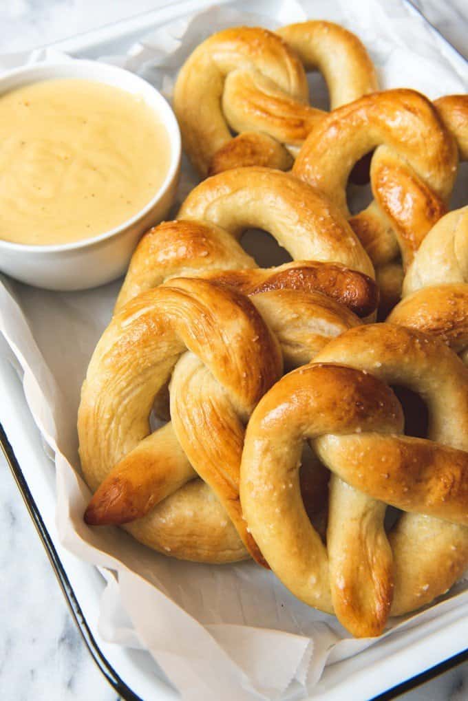 An image of homemade soft pretzels with a side of cheesy dipping sauce.