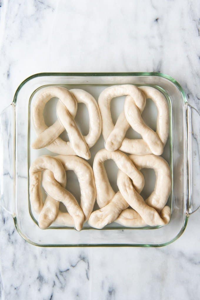 An image of homemade soft pretzels in a baking soda water bath before baking.