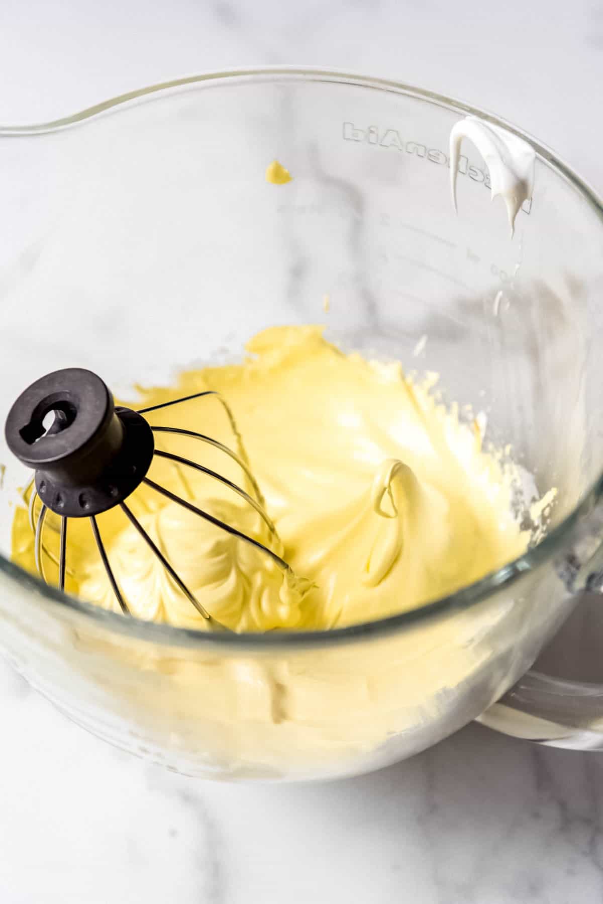 An image of egg whites whisked into stiff peaks and dyed yellow.