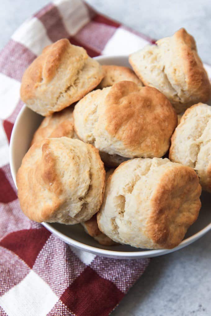 An image of a bowl of flaky, fluffy buttermilk biscuits in a bowl.