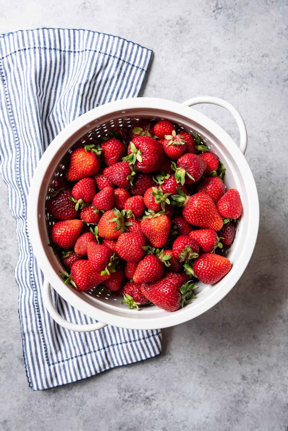Washed fresh strawberries in a white colander.