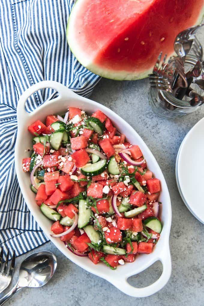 An image of a cucumber and watermelon summer salad that goes great with barbecue as a cool, refreshing side dish.