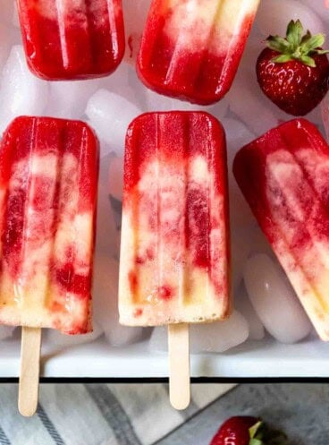 An image of swirled strawberry pineapple popsicles with a hint of coconut.