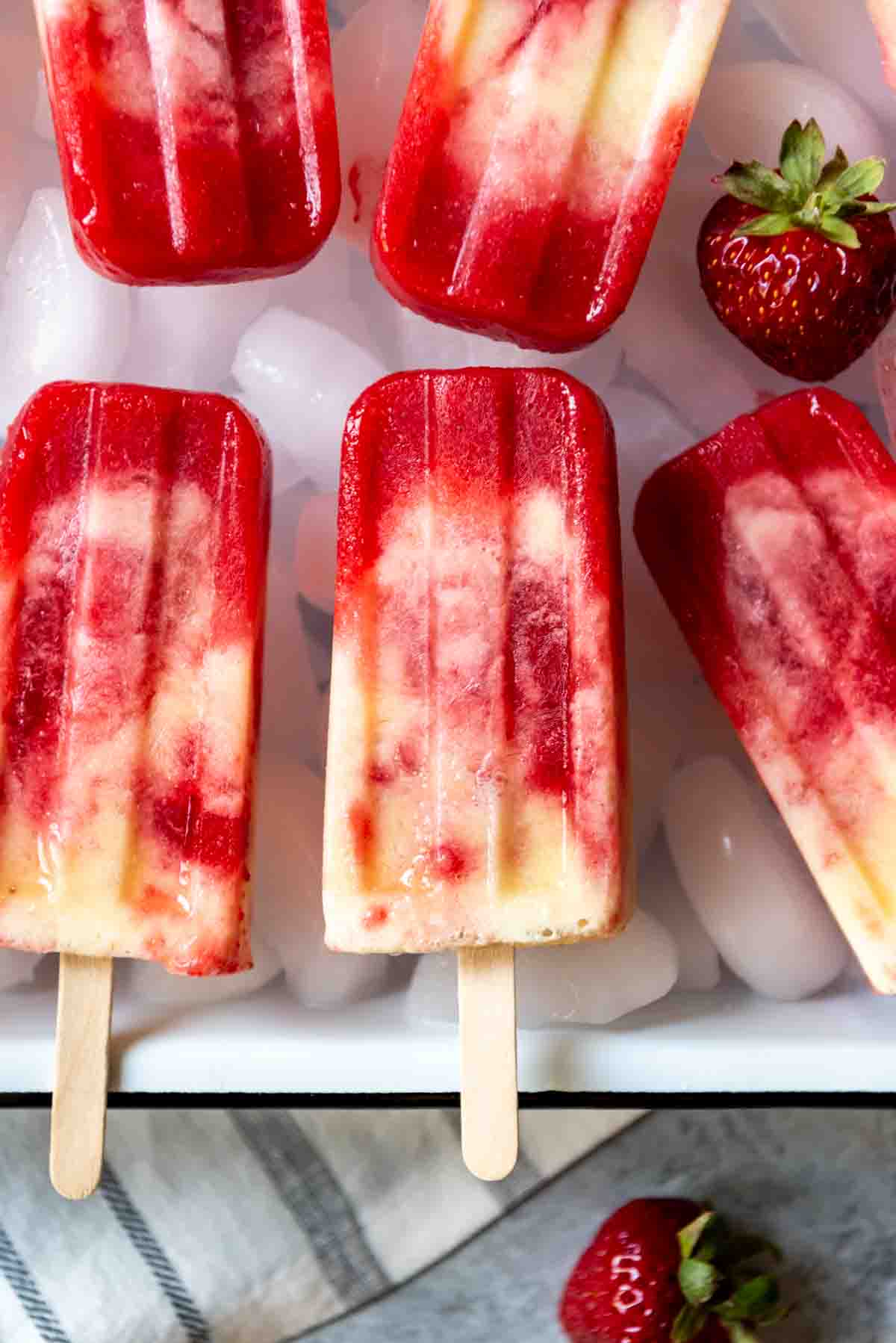 An image of swirled strawberry pineapple popsicles with a hint of coconut.