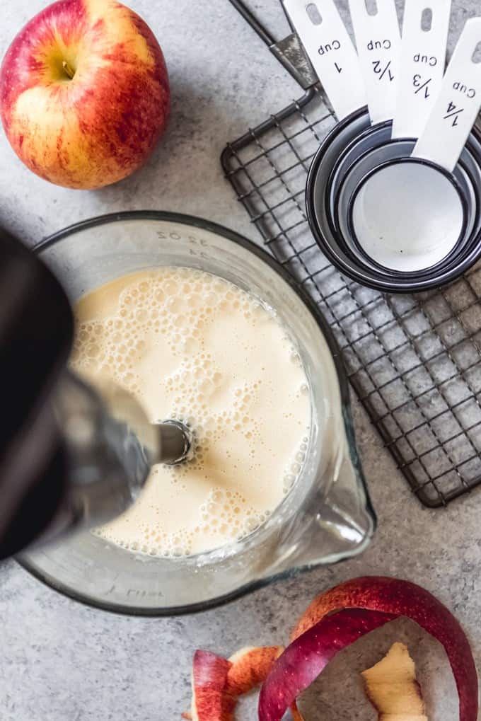 An image of the pancake batter for German apple pancakes with an immersion blender in it to mix the batter together.